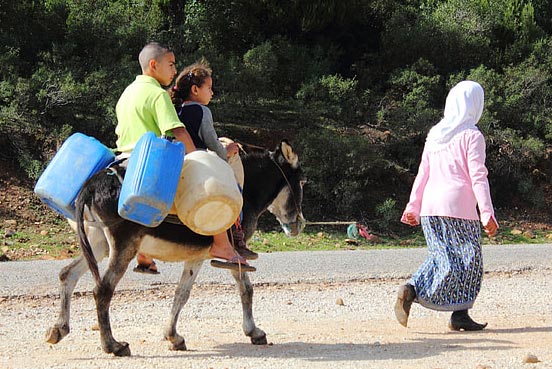 kids riding a donkey in Africa